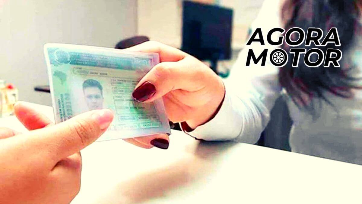 Foto de uma epssoa entregando uma CNH para outra