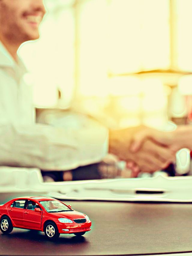 Foto de uma pessoa cumprimentando outra, um carro vermelho na frente da imagem