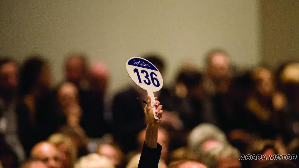 Pessoa levantando a placa em um leilão.