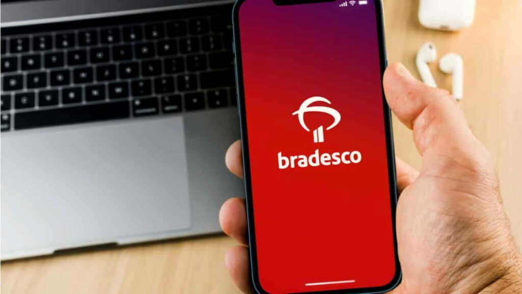 Foto de uma pessoa com um celular entrando no App do Bradesco
