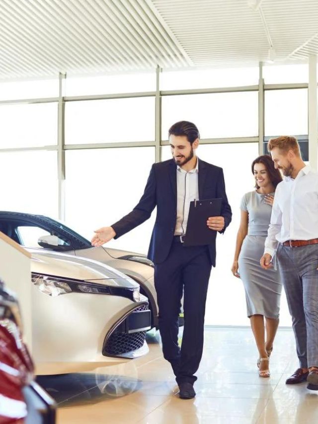 Foto de pessoas conferindo carros em uma concessionária