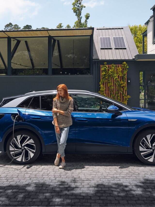 Mulher encostada no VW ID.4 2023.