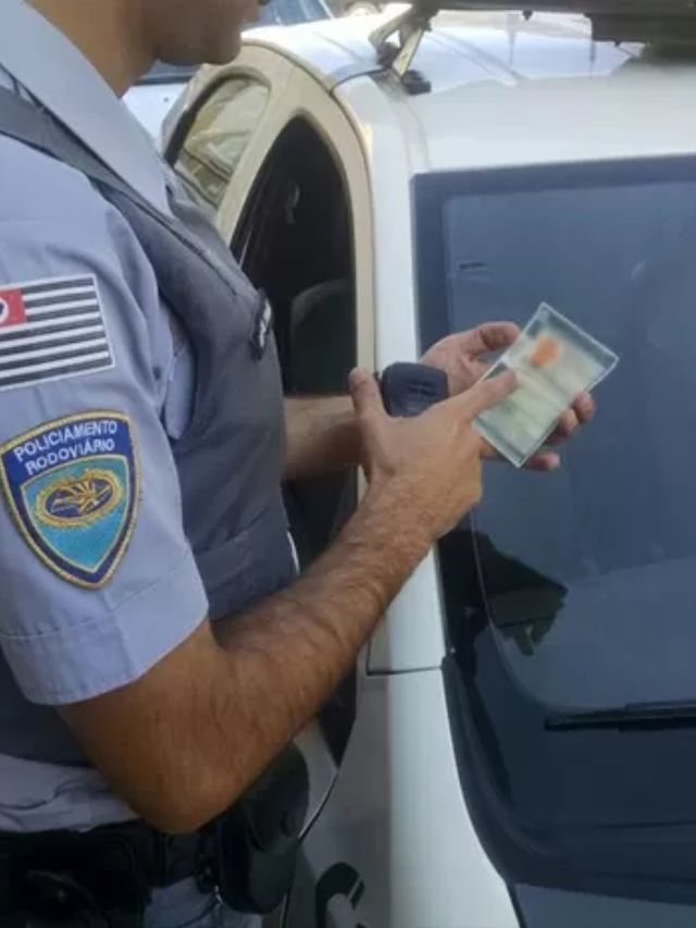 Policial com a CNH na mão.