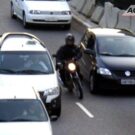 Motoqueiro passando pelo meio dos carros.