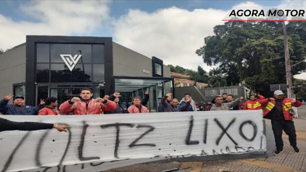 Pessoas manifestando na frente de uma loja da Voltz.