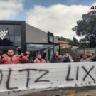 Pessoas manifestando na frente de uma loja da Voltz.