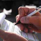 Pessoa escrevendo uma folha