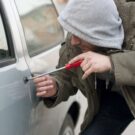 Homem roubando carro com chave de fenda
