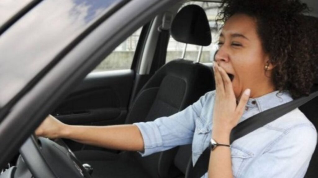 Mulher bocejando no carro