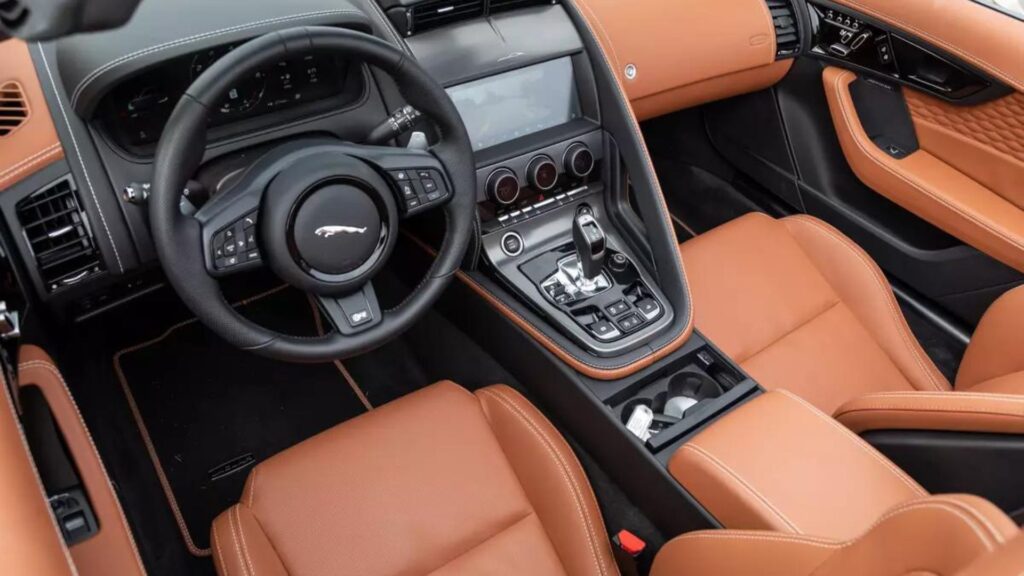 Interior do Jaguar F-Type 2025 com os bancos e detalhes do painel em marrom.