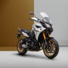 Yamaha Tracer 900 GT 2025 branca com dourado em fundo branco com marrom.