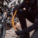 Homem roubando moto cortando corrente na roda.