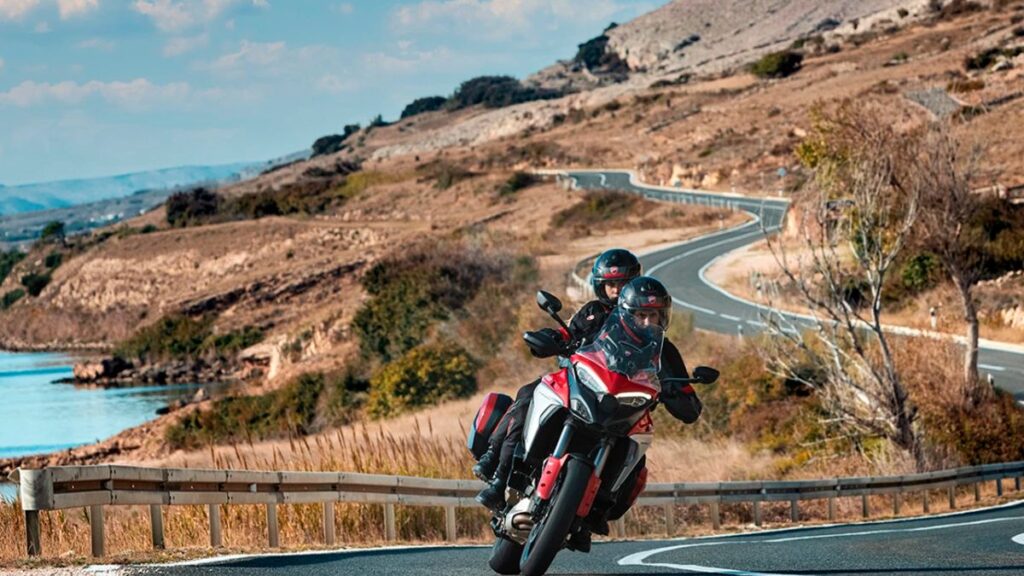 Ducati Multistrada V4 S 2025 em movimento na estrada com passageiro.