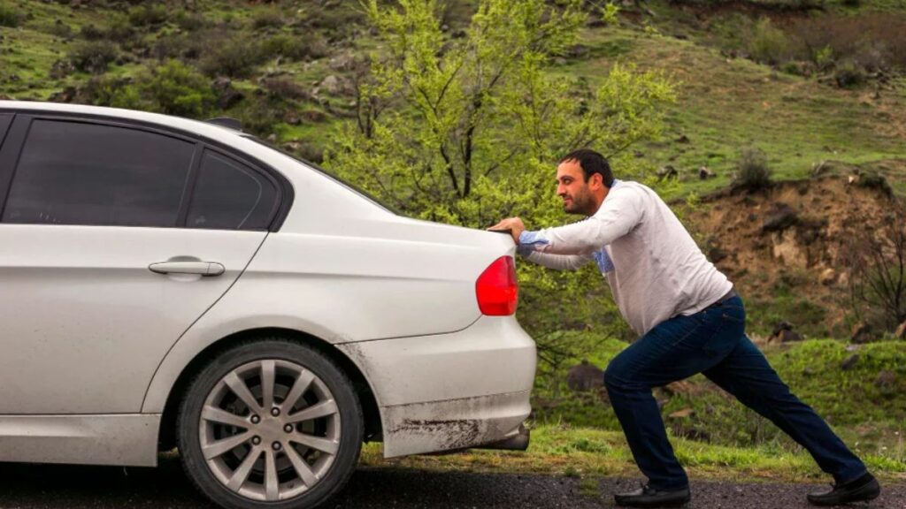 Homem empurrando carro automático branco.