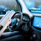 Mulher lendo livro dentro de carro.