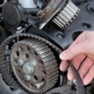 Um mão na correia dentada de um motor