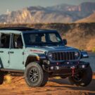 Jeep Wrangler azul parado na diagonal.