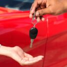 Pessoa entregando chave do carro para outra pessoa.