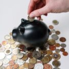 Pessoa colocando dinheiro em um cofre.