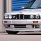 BMW 318i 1991 branco parado na diagonal.