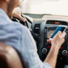 Mexendo no celular enquanto dirige.