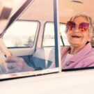 Idosa em carro antigo.