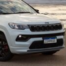 Jeep Compass branco na areia parado.