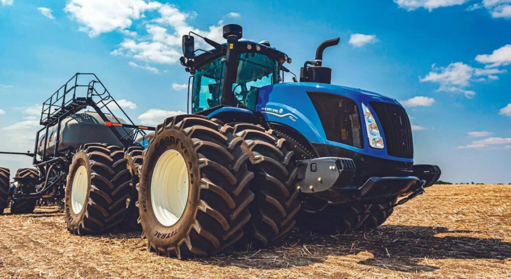 Trator New Holland azul parado na diagonal.