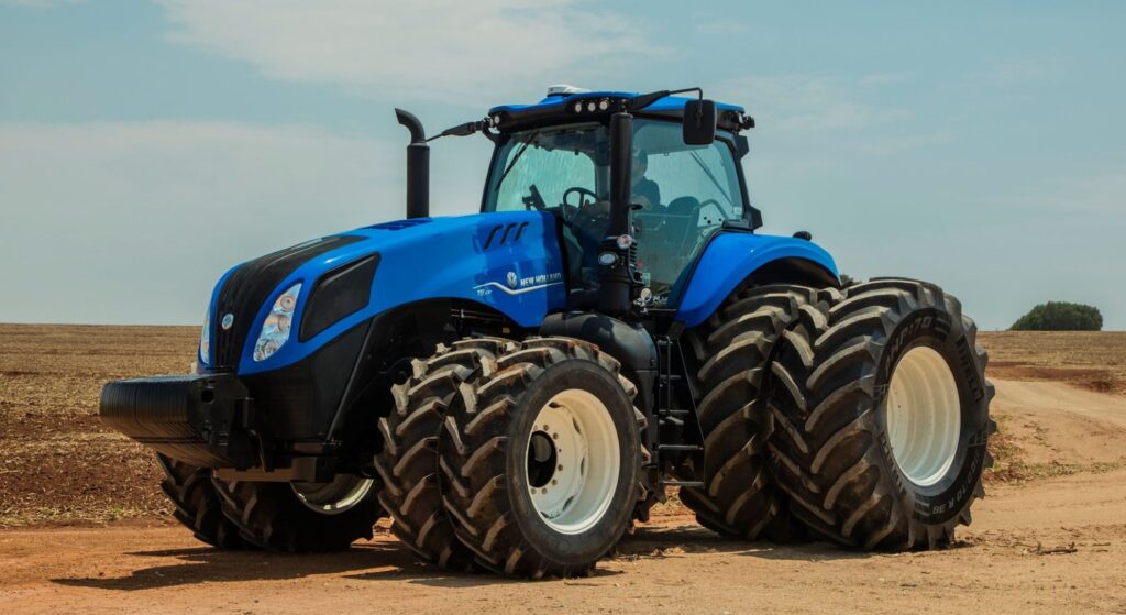 Trator New Holland azul parado na diagonal.