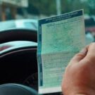 Pessoa segurando documento de ipva.