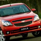 Chevrolet Agile vermelho parado de frente.