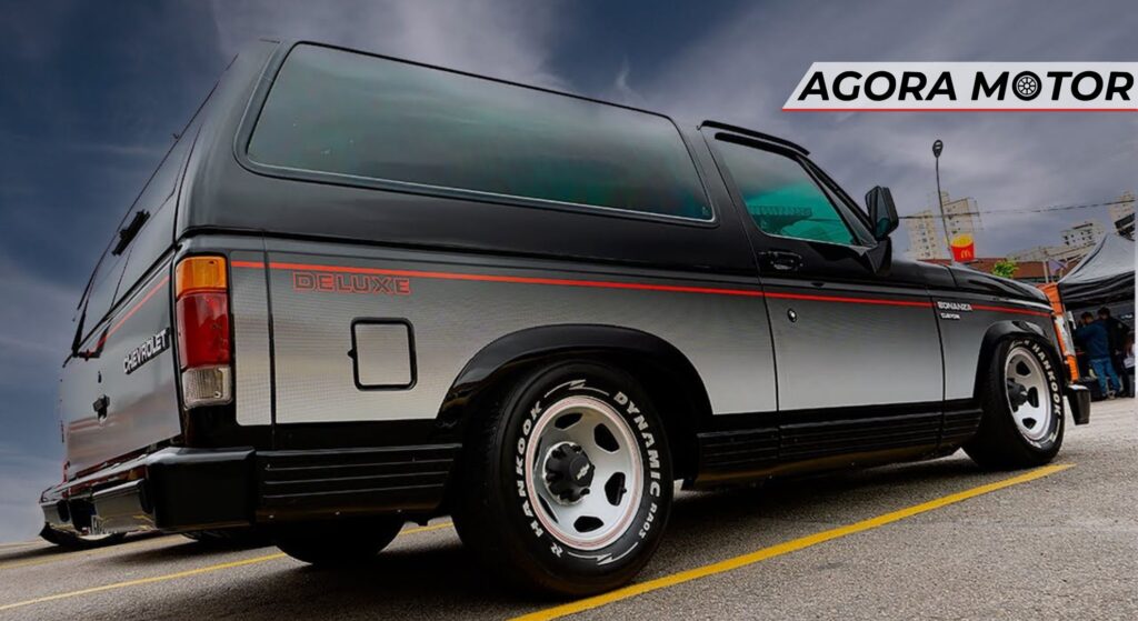 Chevrolet Bonanza preto parado de lado.