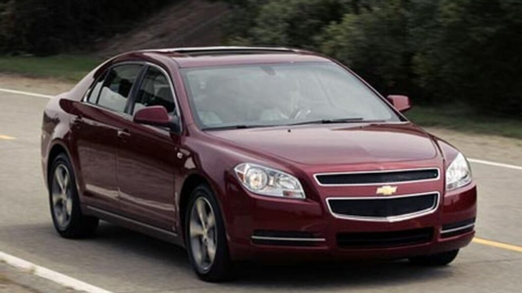 Chevrolet Malibu vermelho na estrada.