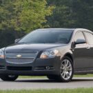 Chevrolet Malibu cinza na estrada.