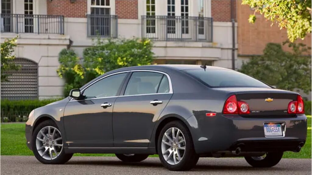 Chevrolet Malibu cinza na diagonal.