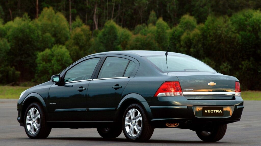 Chevrolet Vectra verde parado na diagonal.