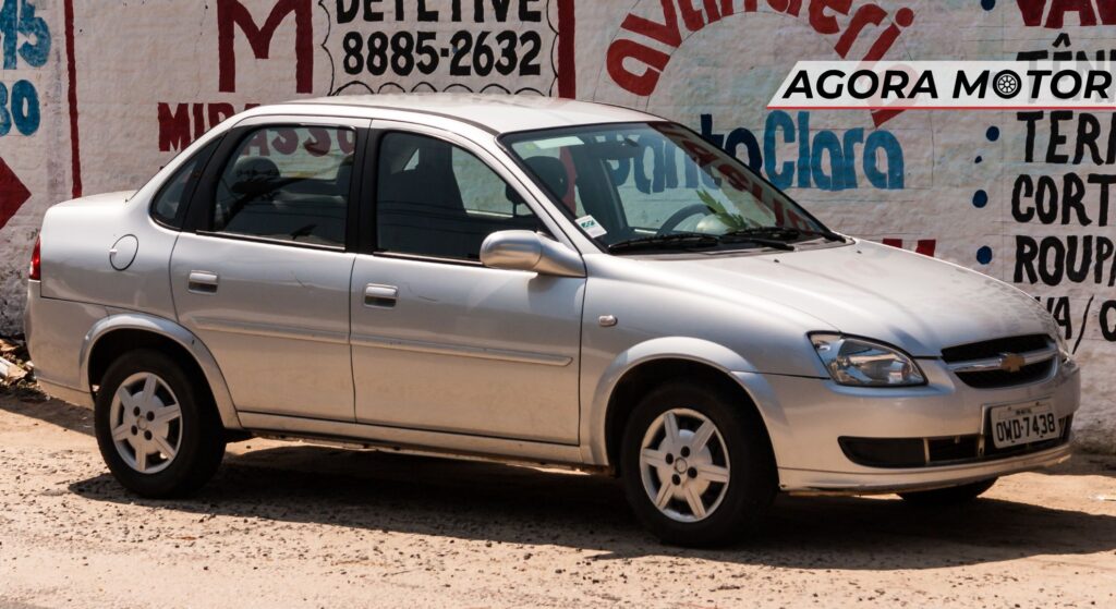 Chevrolet Classic prata parado de lado.