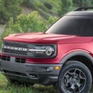 Ford Branco vermelho parado de lado.