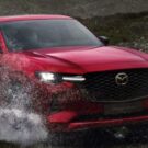 Mazda CX-60 2025 vermelho passando em uma poça de agua.