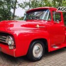 Ford F-100 vermelho parado na diagonal.