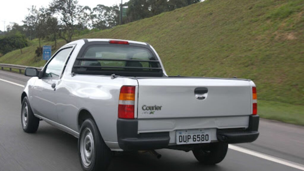 Ford Courier prata no asfalto