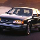 Ford Taurus preto na estrada.