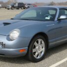 Ford Thunderbird azul estacionado na vaga.