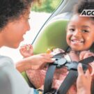 Mãe colocando sua filha na cadeirinha.