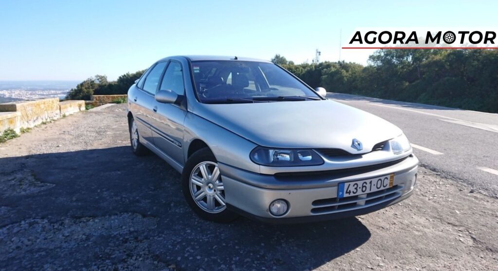 Renault Laguna prata parado na diagonal.