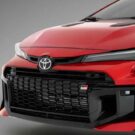 Toyota Corolla vermelho parada na diagonal.