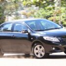 Toyota Corolla 2010 xei preto saindo de lado.