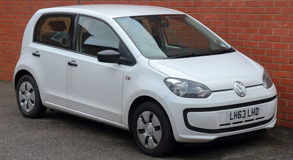 Volkswagen Up branco parado na diagonal.