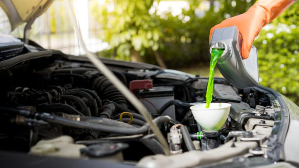Anticongelante sendo colocado no radiador de carro.