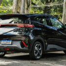 Traseira do BYD Dolphin Mini preto parado na estrada.